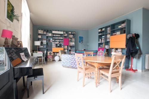 Cette chambre comprend une table, des chaises et un piano. dans l'établissement Clem - Appartement dans le coeur d'Arles, à Arles