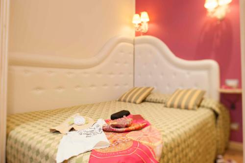 a bedroom with a bed with a white headboard at Hotel Astigiana & Appartamenti in Varazze