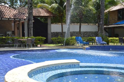 a swimming pool with a fountain in a resort at Hotel Boutique Villas de San Sebastián in Villavicencio