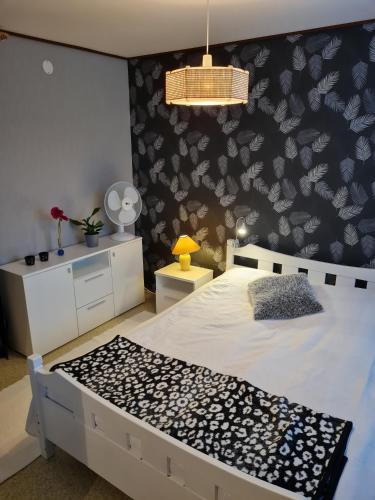a bedroom with a bed with a black and white wall at Syväraumankatu 32 as 3 in Rauma