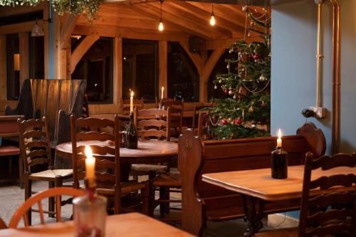Ye Old Ferrie Inn في سيموند يات: مطعم بطاولات عليها شموع وشجرة عيد الميلاد