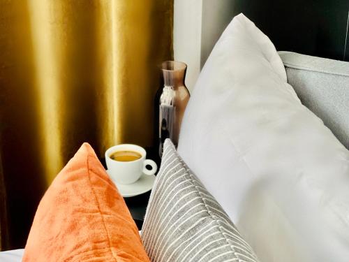 a cup of coffee sitting on a bed with pillows at Canaryislandshost l Balcón del Mar in Puerto del Carmen