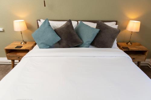 1 dormitorio con 1 cama grande con almohadas y 2 lámparas en Ye Old Ferrie Inn en Symonds Yat