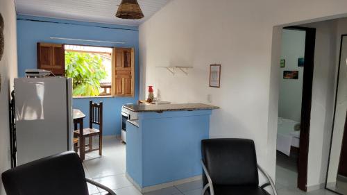 a kitchen with a refrigerator and chairs in it at Pousada Simbiose in Arraial d'Ajuda
