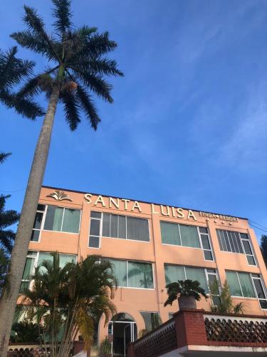 a building with a palm tree in front of it at Hotel Santa Luisa Finca Boutique in Tecolutla