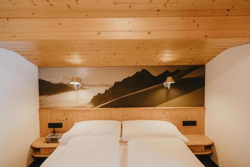 a bed in a room with a wooden ceiling at Gästehaus Kolp in Sankt Anton am Arlberg