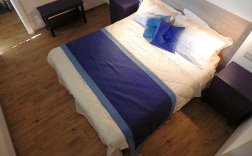 a large bed with blue pillows on top of it at B&B Le Vele in Maruggio