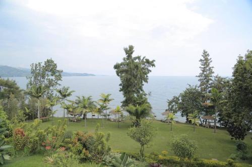 a park with trees and the ocean in the background at Hakuna Matata Lodge in Gisenyi