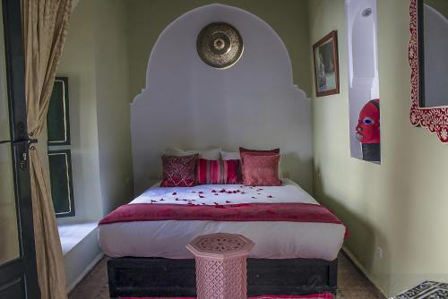 a bedroom with a large bed with red pillows at Riad Dar Habiba by Garden Wonders in Marrakech