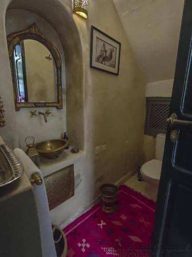 a bathroom with a sink and a toilet and a mirror at Riad Dar Habiba by Garden Wonders in Marrakech