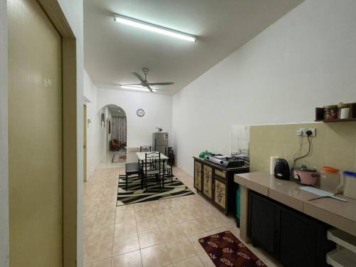 a kitchen with a table and chairs in a room at Rose Homestay in Sitiawan