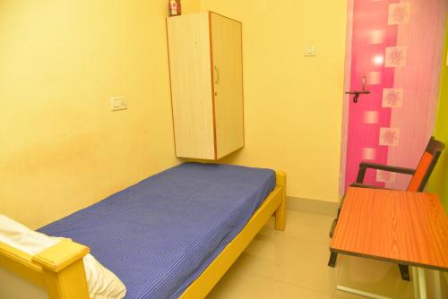 una pequeña habitación de hospital con una cama y un armario en bk residency, en Khammam