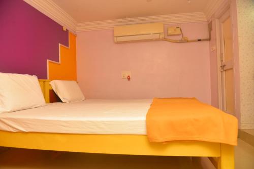 Un dormitorio con una cama con una manta naranja. en bk residency, en Khammam