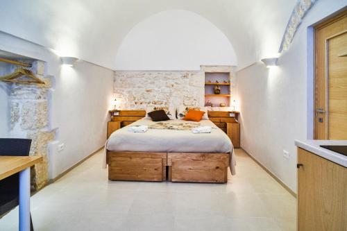 1 dormitorio con cama y pared de piedra en Casetta Lulù, en Ostuni