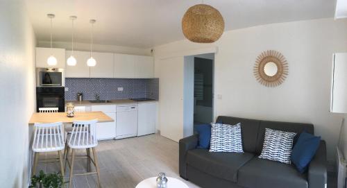un salon avec un canapé et une cuisine dans l'établissement Rez de jardin en Accès direct mer(100m) près de la Thalasso, à Cabourg