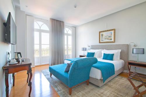 a bedroom with a large bed and a blue chair at Villa Bela Vista in Sintra