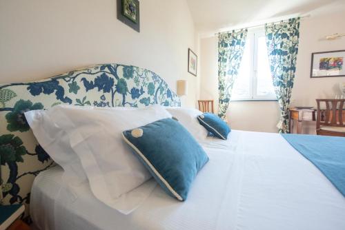 
a white bed with a blue comforter and pillows at Hotel Al Terra Di Mare in Levanto
