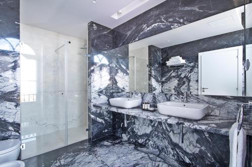 a black marble bathroom with two sinks and a shower at Villa Bela Vista in Sintra