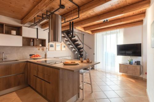 a kitchen with wooden ceilings and a kitchen island at Casa del Borgo "Aria & Acqua" sul Lago Maggiore in Maccagno Inferiore