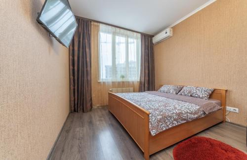 a bedroom with a bed and a tv and a window at Apartment with View on 24 floor in Kyiv