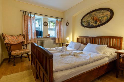 a bedroom with a large bed and a chair at Pension Brusenka in Bystřice pod Hostýnem