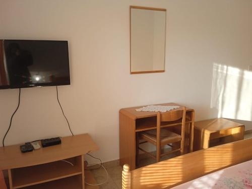 een kamer met een tv en een tafel en een stoel bij Luna Tsuki Two in Rovinj