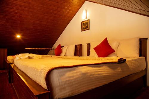 a bedroom with two beds with red and white pillows at Moon Plains Luxury Apartments in Nuwara Eliya