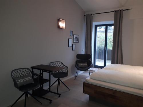 a bedroom with a bed and a table and chairs at Pension in der Alten Mälzerei in Angermünde