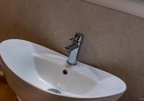 een wastafel in de badkamer met een kraan aan de muur bij RESIDENCE BLUMAR 2 in Lido di Jesolo