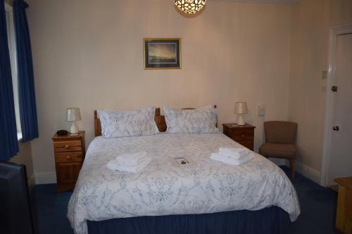 a bedroom with a bed with two towels on it at Cragside Guest House in Keswick