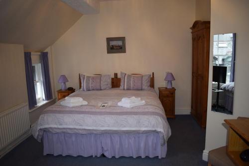 a bedroom with a bed with two towels on it at Cragside B&B in Keswick
