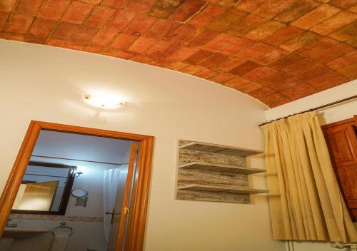a room with a brick ceiling and a mirror at Can Misse in Collbató