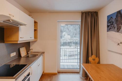 a kitchen with a table and a large window at Gästehaus Kolp in Sankt Anton am Arlberg