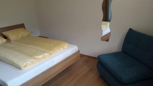 a small bedroom with a bed and a chair at Haus Spitaler in Hippach