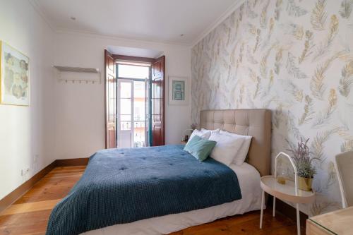 una camera con letto e copriletto blu di Your New Home in Lisbon - AC and Fast Wi-Fi a Lisbona