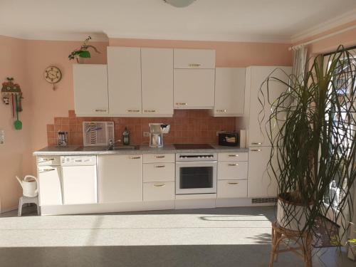 uma cozinha com armários brancos e um forno com placa de fogão em Haus Bielefeld em Elmen