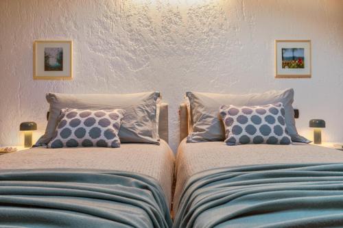 two beds sitting next to each other in a bedroom at Casa del Borgo "Aria & Acqua" sul Lago Maggiore in Maccagno Inferiore
