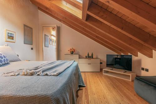 a bedroom with a bed and a flat screen tv at Casa del Borgo "Aria & Acqua" sul Lago Maggiore in Maccagno Inferiore