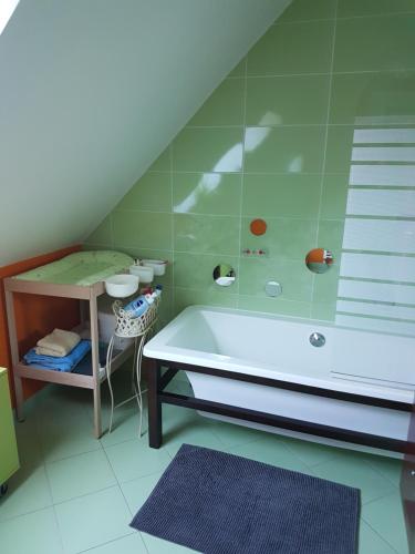La salle de bains est pourvue d'une baignoire, d'une table et d'un tabouret. dans l'établissement Charmante chambre d'hôtes en Normandie, à Valognes