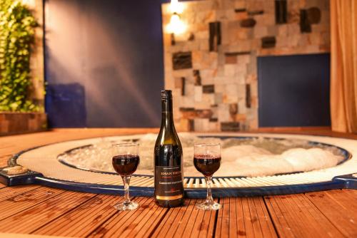 a bottle of wine and two glasses on a table at Hotel Iceberg Bansko in Bansko