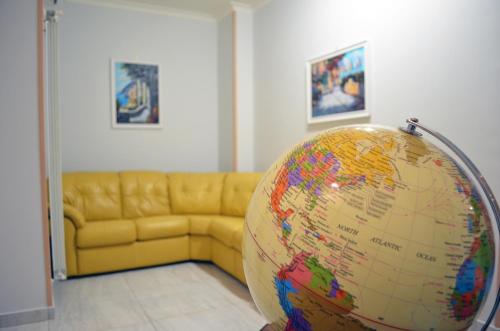 a large globe in a room with a couch at Midway House Italy Apartment in Sant'Egidio del Monte Albino