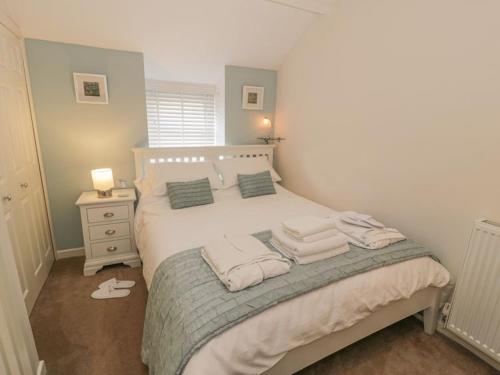 a bedroom with a bed with towels on it at Kirrin Cottage in Conwy