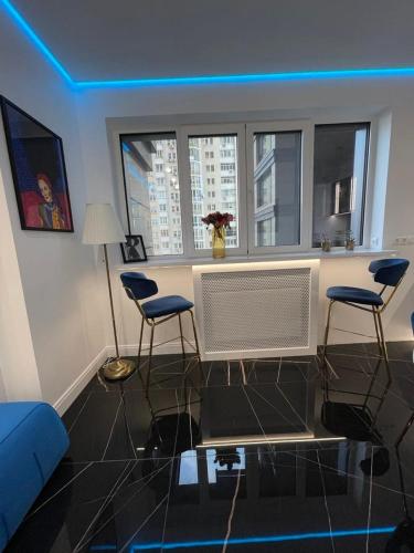 a living room with a table and three chairs at 1 room 65m2 center of Obolon near River side. in Kyiv
