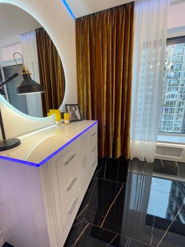 a bathroom with a vanity with a mirror and a window at 1 room 65m2 center of Obolon near River side. in Kyiv
