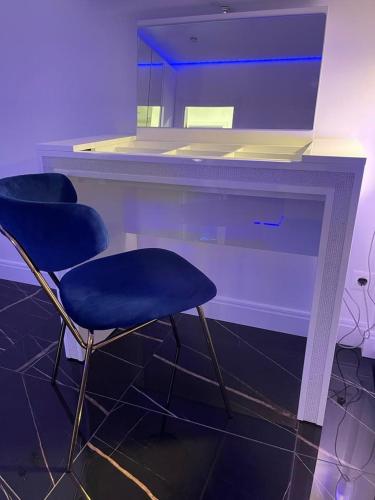 two blue chairs sitting next to a fireplace with a mirror at 1 room 65m2 center of Obolon near River side. in Kyiv