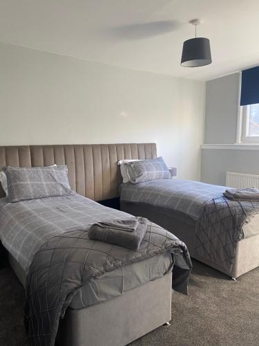 a bedroom with two beds and a window at Town Centre Holiday Let in Hawick