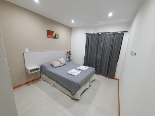 1 dormitorio con 1 cama con 2 toallas en Rialto Departamentos Amplios luminosos Cochera y asador en Villa Mercedes