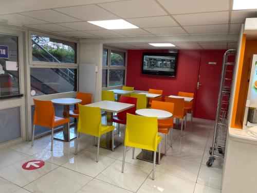 a dining room with tables and chairs in a restaurant at Premiere Classe Dunkerque Saint Pol Sur Mer in Saint-Pol-sur-Mer