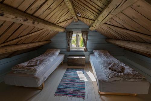 an attic room with two beds and a window at Cozy cabin with stunning view in Alstad