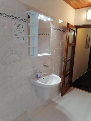 a bathroom with a sink and a mirror at Penzion Stella in Luhačovice